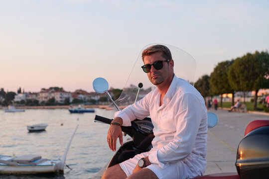 Man On Scooter By The Seaside At Sunset In Umag Wearing White Shirt And Sunglasses