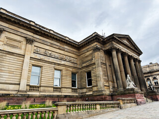 Obraz premium Neoclassical Walker Art Gallery museum building in Liverpool, UK with grand columns, stone statues and ornate facade on a cloudy day