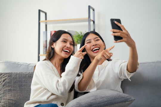 Two Asian girls use their smartphones to make a video call with their friends