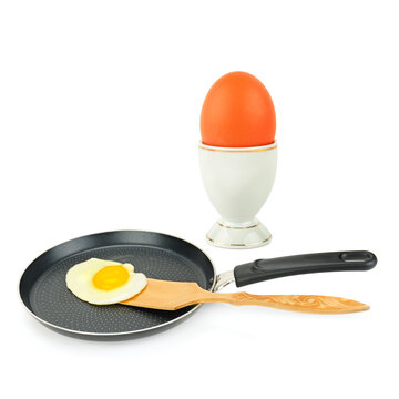Fried Egg in a Frying Pan and Raw Brown Egg in Cup Isolated on White Healthy Breakfast Cooking Concept with Fried and Whole Eggs