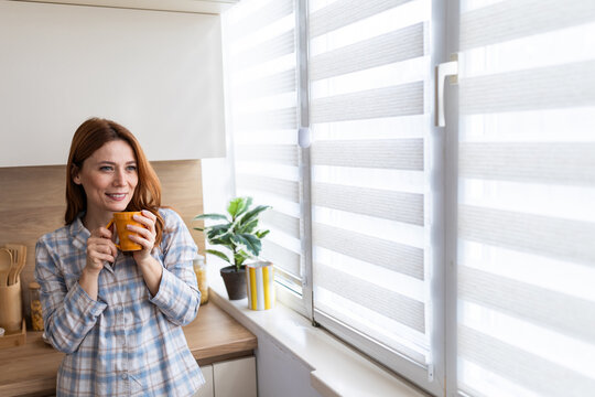 Woman enjoys coffee in modern kitchen at home