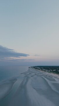 4K vertical video of Mayflower Beach on Cape Cod showing a calm ocean at low tide at sunset, Dennis, Massachusetts, MA, USA