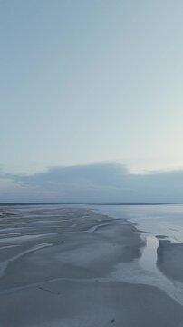 4K vertical video of Mayflower Beach on Cape Cod showing a calm ocean at low tide at sunset, Dennis, Massachusetts, MA, USA