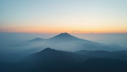 Fototapeta premium A serene landscape featuring layers of majestic mountain peaks shrouded in thick morning mist fog.