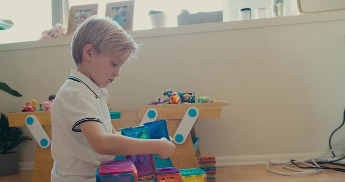 Little boy building with magnetic construction blocks