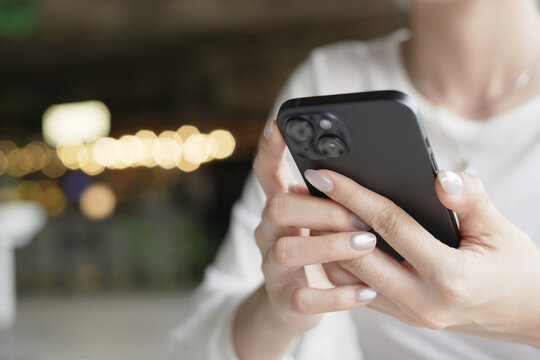 woman holds smart phone in her hands and scrolls through the news feed. Close up of hand uses mobile. point finger on screen, texting text message.