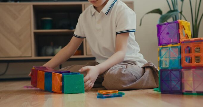 Creative child playing with magnetic constructor