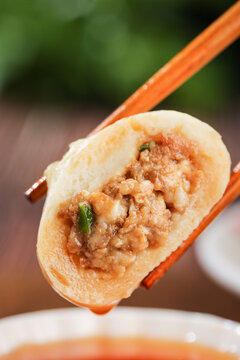 Chinese Xiaolongbao Soup Dumpling with Meat Filling Held by Chopsticks - Traditional Asian Steamed Bao