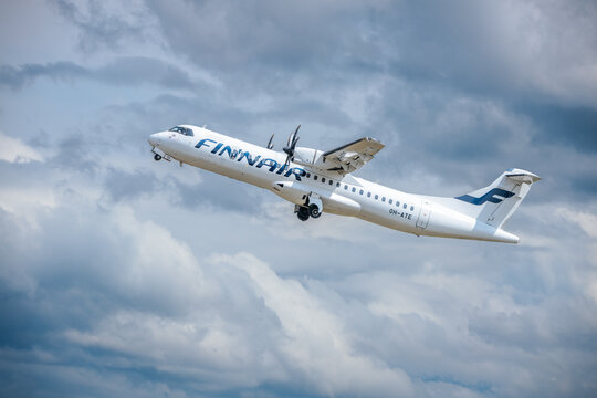 Riga, Latvia - July 06, 2026: Finnair ATR 72 aircraft taking off against a backdrop of dramatic clouds in a clear blue sky during daytime