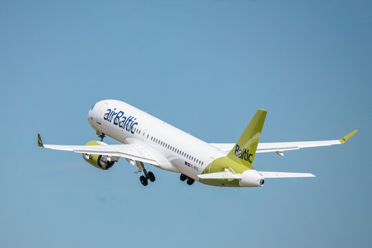 Riga, Latvia - July 06, 2026: AirBaltic passenger airplane taking off against a clear blue sky, showcasing the aircraft's distinctive green and white livery