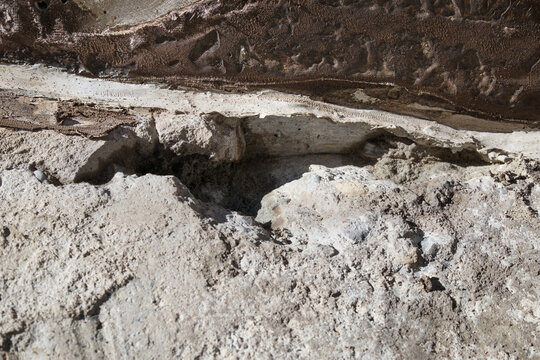 Deep crack in concrete foundation of basement or patio. Stripped of membrane and cleaned up with grinder. Site prep for waterproofing membrane. Selective focus.