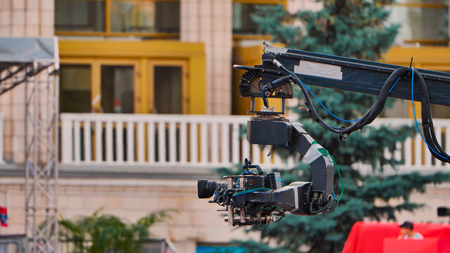 Filmmaking equipment showing a professional video camera mounted on a jib arm at an outdoor location