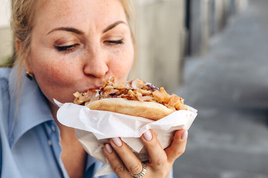 Woman Eating Grilled Chicken Shawarma Wrap With Yogurt Sauce Close up Street Food Bite , Sandwich Gyro or   Doner Kebab Outdoors