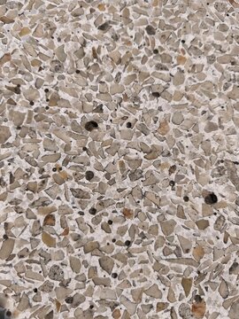 Texture of terrazzo floor surface with high density mixture of small gray and beige marble stone chips.