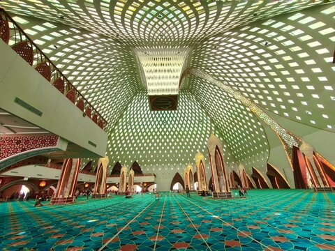 Bandung, Indonesia - July 08 2026: Wide angle interior view of Al Jabbar Grand Mosque dome with intricate and beautiful white ceiling mesh pattern.