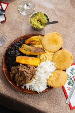 Venezuelan Pabell&oacute;n. Arepas, shredded meat, and fried plantains