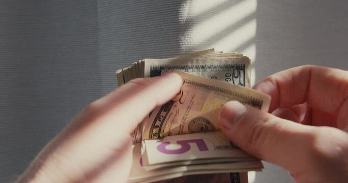 Male hands counting stack of us dollar bills
