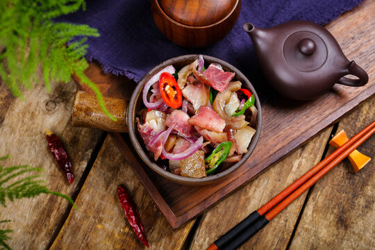 Spicy sliced pork with onions and chili in rustic Asian style setting