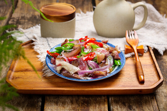 Stir Fried Pork Head with Red Onions and Chili on Rustic Wooden Tray