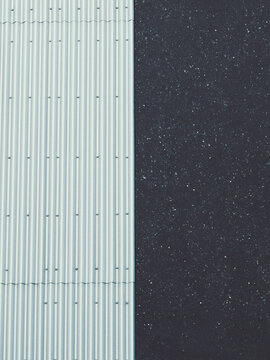 Tekstura podzielona pionowo na jasną blachę falistą i ciemny chropowaty panel elewacyjny