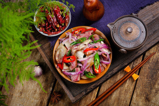Stir Fried Pork with Red Onions and Chili Peppers on Rustic Table