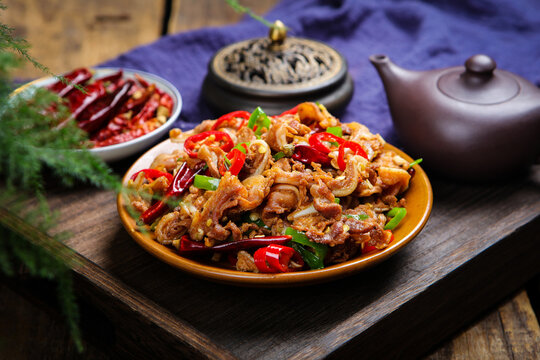 Spicy stir fried pork with chili peppers on rustic wooden table