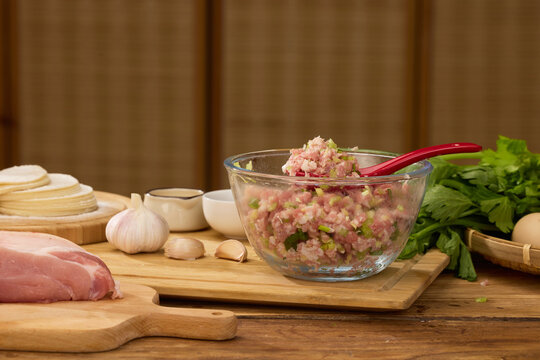 Homemade pork dumpling filling with wrappers, garlic and fresh greens