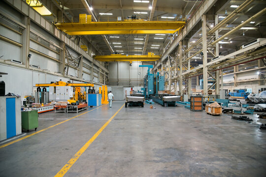 Industrial Factory Floor with Overhead Cranes and Heavy Machinery