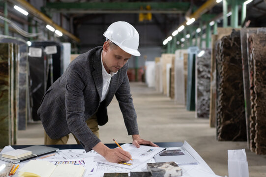 Focused man architect creating new blueprint