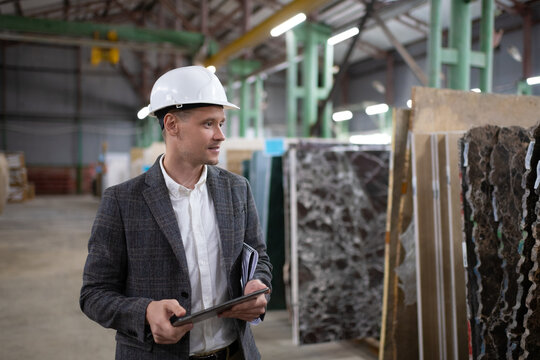Businessman picking materials in stone warehouse
