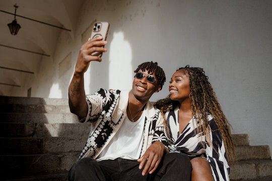 An African couple taking a selfie in the city