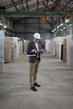 Male worker checking marble in warehouse
