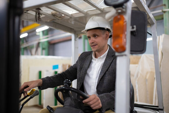 Storehouse male worker controlling lift truck