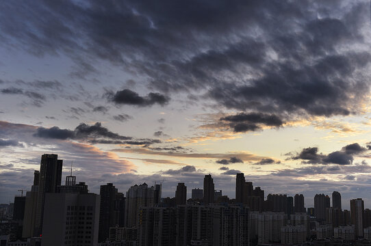 Wuhan City Skyline at Sunset with Dramatic Clouds and Sunlight Reflection