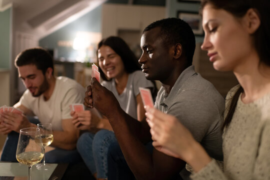 African American guy playing cards with friends