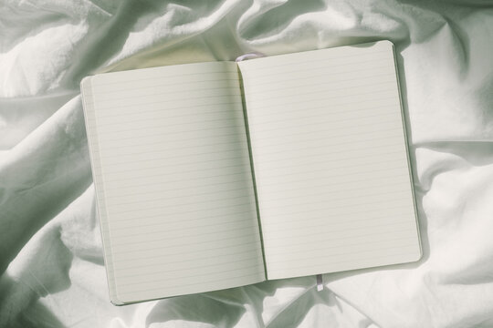 Open notebook on white bedding