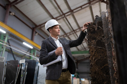Focused male manager exploring marble slabs