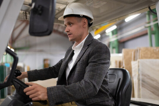 Professional male worker of warehouse operating forklift