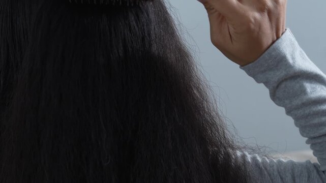 woman sticking brushing her hair falling out and have many hair loss on the comb. problem of Damaged and frizzy. Healthcare and medical concept.
