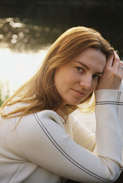 A woman rests her hand in her hair on a quiet afternoon
