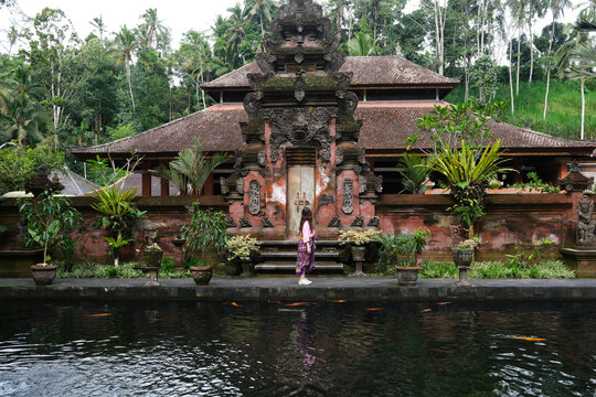Woman Standing at Traditional Balinese Temple by Water