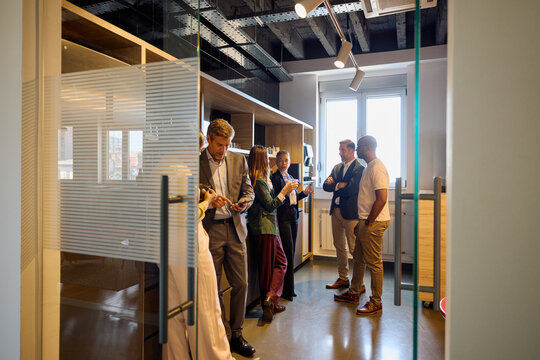 A group of colleagues gathered in the hallway