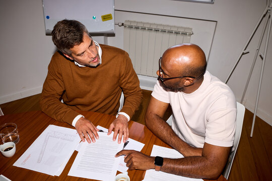 Men discuss paperwork together