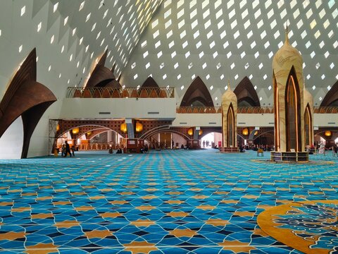 Bandung, Indonesia - July 08, 2026: The beautiful interior of Al-Jabbar Grand Mosque prayer hall with iconic ceiling structures and gold-colored decorative pillars.