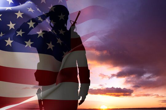 Silhouette of a soldier with USA flag against the sunset. Memorial Day, Veterans Day