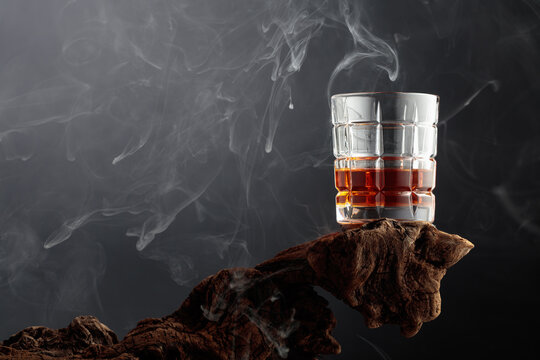 Smoked old-fashioned cocktail on weathered driftwood.