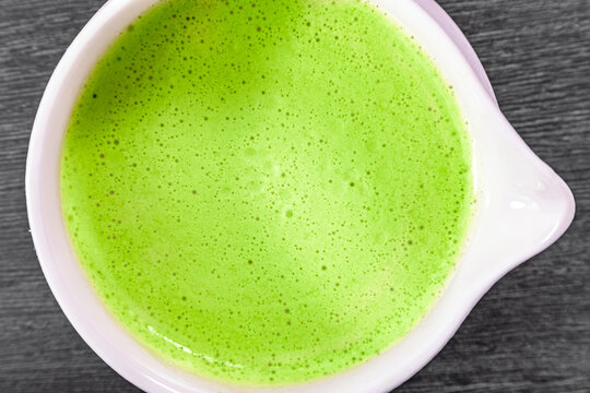 Traditional green matcha tea in white porcelain bowl. Healthy organic Japanese beverage with frothy texture. Authentic ceremony drink for relaxation, natural energy, and detox lifestyle