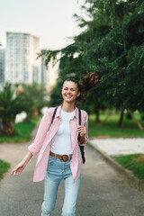 Naklejka premium Woman outdoors, smiling and relaxed, in casual fashion at a park with greenery, daylight and breeze, capturing a bright lifestyle moment.
