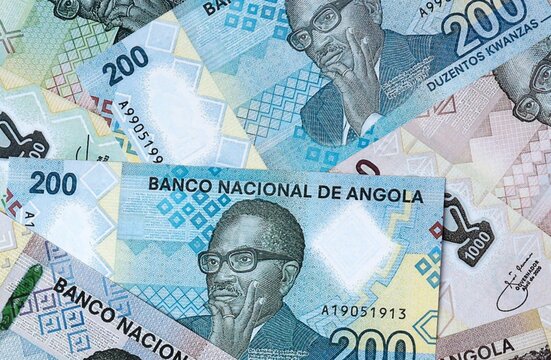 Angolan kwanza money bills in pile on table. Angola AOA currency cash close up