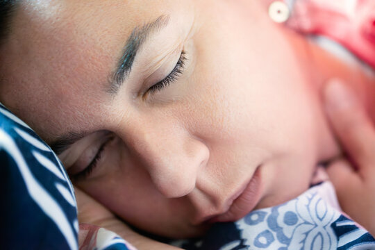 Close Up Face Portrait of a Serene Caucasian Woman Sleeping Peacefully in Bed with Closed Eyes and Head Resting on a Pillow